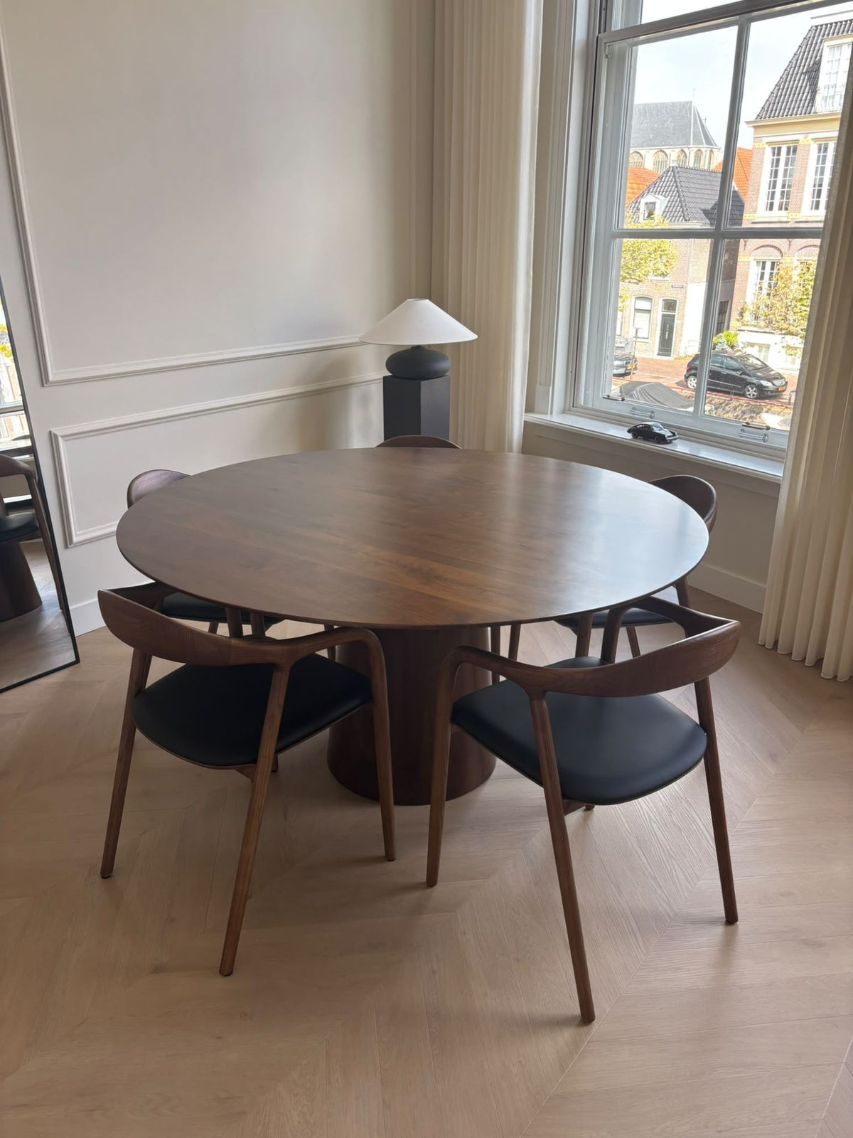 Ronde walnoten eettafel met eetkamerstoelen bij een klant thuis